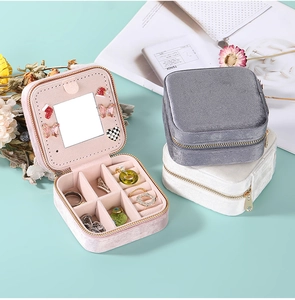 Detail view of pink, grey, and white velvet jewelry boxes with mirrors and slots