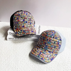 Detailed view of handmade colorful beads and pearls on black and blue baseball caps