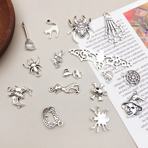 Detailed view of assorted vintage silver Halloween pendants including spider and skull charms