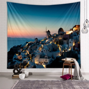 Santorini sunset landscape wall tapestry displayed on white brick wall in a modern room