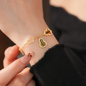 Detail of 18K gold-plated Wu Lou bracelet with tiger eye stone and pavé zircon on wrist