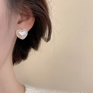 Elegant heart-shaped stud earring set with pearl and zircon inlay in gold finish