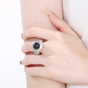 Gros plan d'une bague en acier vintage à texture martelée et incrustation de pierre noire