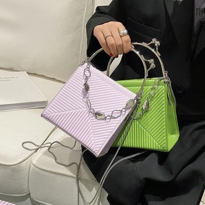 Detail of quilted handbags with metallic handles and chain straps in purple and green