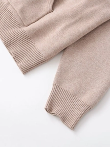 Detailed close-up of ribbed cuffs and hem on an oatmeal knit top and pants set