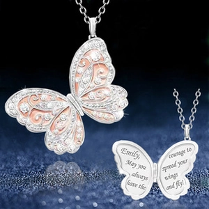 Macro detail of butterfly pendant showing custom engraving on silver and rose gold metal