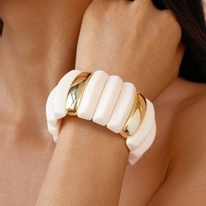 Detail of chunky acrylic resin stretch bracelet with cream and gold geometric blocks