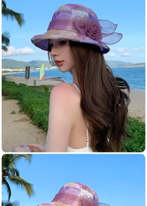 Detail of purple summer sun hat with elegant sheer flower decoration for women outdoors