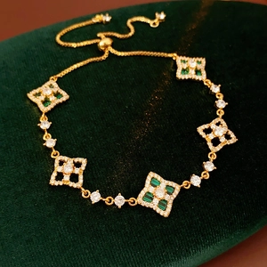 Détail d'un bracelet doré réglable avec trèfles en malachite et pierres de zircon