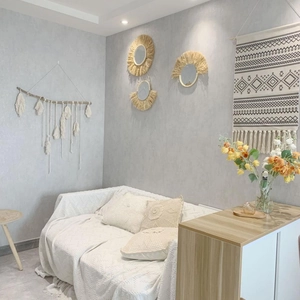 Dettaglio di specchi da parete boho in rafia intrecciata a mano e decori con nappe