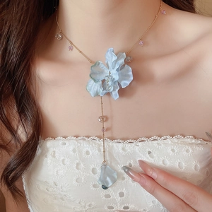 Close-up of blue fabric flower pendant necklace with elegant crystal tassels for women