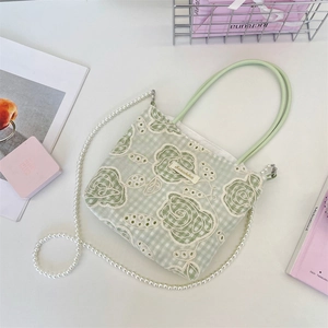 Détail du sac cabas à carreaux verts avec dentelle florale et chaîne en perles