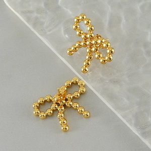 Orecchini a fiocco con perline in acciaio inossidabile placcato oro 18k su sfondo grigio
