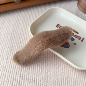 Close-up of soft brown plush hair clip texture and fuzzy material details on a tray