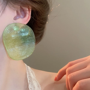 Macro detail of translucent light green resin earrings with unique water ripple texture