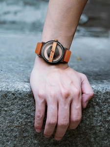 Detail van het TOMI uniseks horloge met bruine lederen band gedragen aan de pols