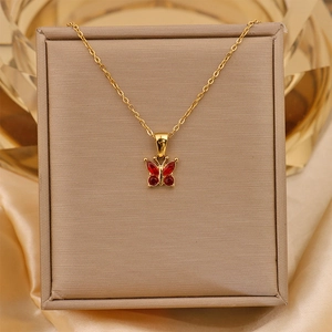 Detail of 18K gold titanium steel necklace with a red zircon butterfly pendant on silk