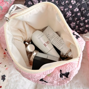 Macro view of the pink quilted makeup bag interior showing large capacity storage