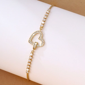 Detail showing gold heart bracelet with micro-pave zircons and adjustable slider clasp