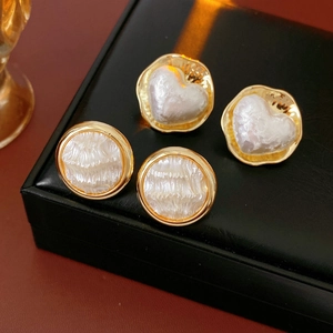 Détail de boucles d'oreilles cœur et rondes plaquées or 16K avec nacre blanche