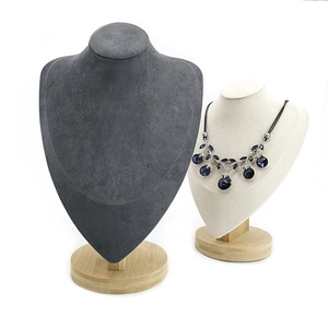 Detail of velvet necklace busts in dark grey and beige with solid wood bases