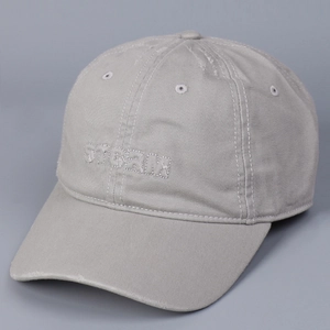Detail of STORM embroidery and distressed brim on light grey washed cotton baseball cap