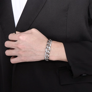 Detailed view of polished stainless steel Cuban chain bracelet on black suit background