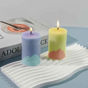 Detail of mountain-shaped relief on colorful cylindrical candles with warm candlelight