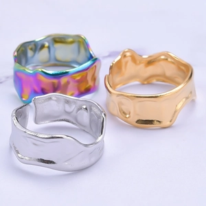 Macro view of stacked irregular hammer-textured rings in rainbow, gold, and silver finishes