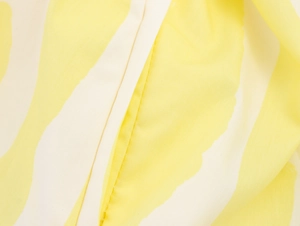 Macro detail of yellow and white abstract printed fabric showing fine stitching and texture