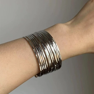 Polished silver stacked multi-layer metal bangles shown on a female wrist detail