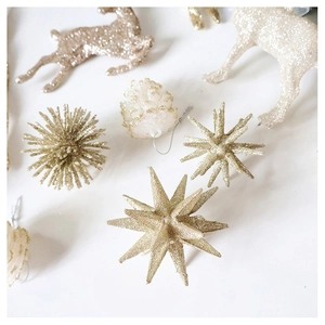 Close-up of glittery gold and cream Christmas ornaments including stars, deer, and pinecones