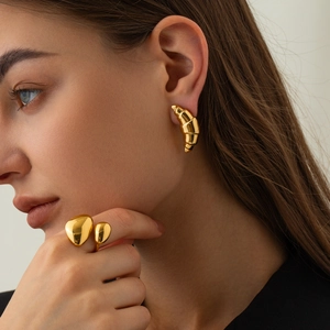 Close-up of 18k gold plated stainless steel croissant earrings on a female model