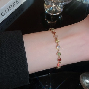 Close-up of gold plated bracelet featuring colorful circular cubic zirconia stones