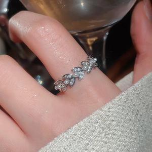 Close-up of silver leaf ring with micro-set zircons and pearls on model's hand