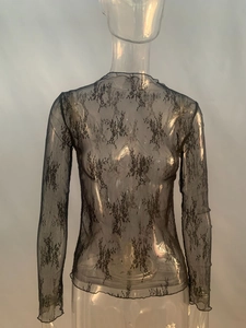 Détail du tissu en maille noire transparente avec broderie florale et bords festonnés
