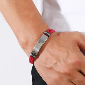 Close-up of a men's red braided leather bracelet with a polished silver metal plate
