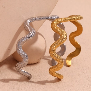 Detail of hammered texture on wavy 18K gold and silver plated stainless steel bangles