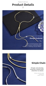 Close-up of sleek gold and silver snake bone chain necklaces on a blue velvet display