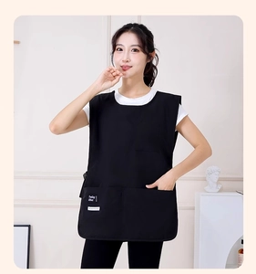 Detail of waterproof black apron vest with two large pockets and minimalist fashion labels