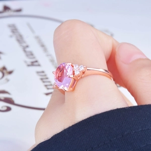 Close-up of a pear-shaped pink diamond ring in rose gold finish on a finger