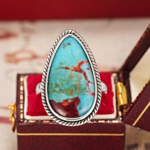 Detalle de anillo vintage de turquesa en forma de pera con borde de metal trenzado