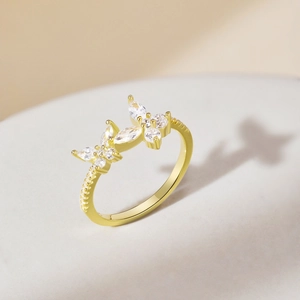 Macro view of gold butterfly rings with sparkling zircon crystals and fine metalwork