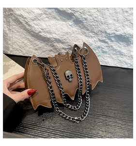 Detail of brown bat-shaped jelly bag with skull decor and thick metal chain strap