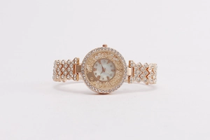 Detailed close-up of rose gold watch with mother of pearl dial and sparkling rhinestones