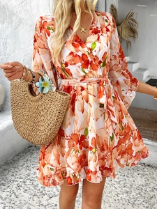 Detail of V-neck printed chiffon dress with waist tie and ruffle hem for summer vacation