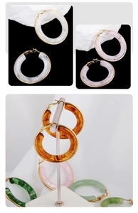 Detailed views of chunky marble and tortoiseshell earrings with gold metal accents