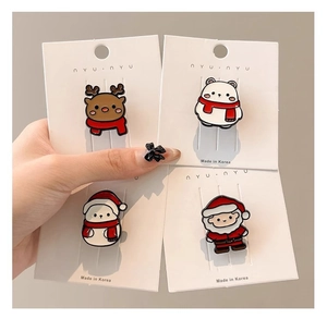 Détail de quatre épingles de Noël en émail avec le Père Noël et des rennes mignons
