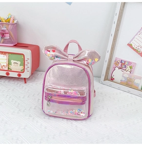 Detailed shot of pink sequined kid backpack with glitter bow and transparent star pocket