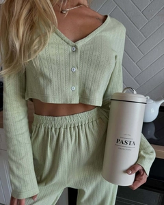 Detail view of light green ribbed knit cardigan and trousers set in lifestyle setting